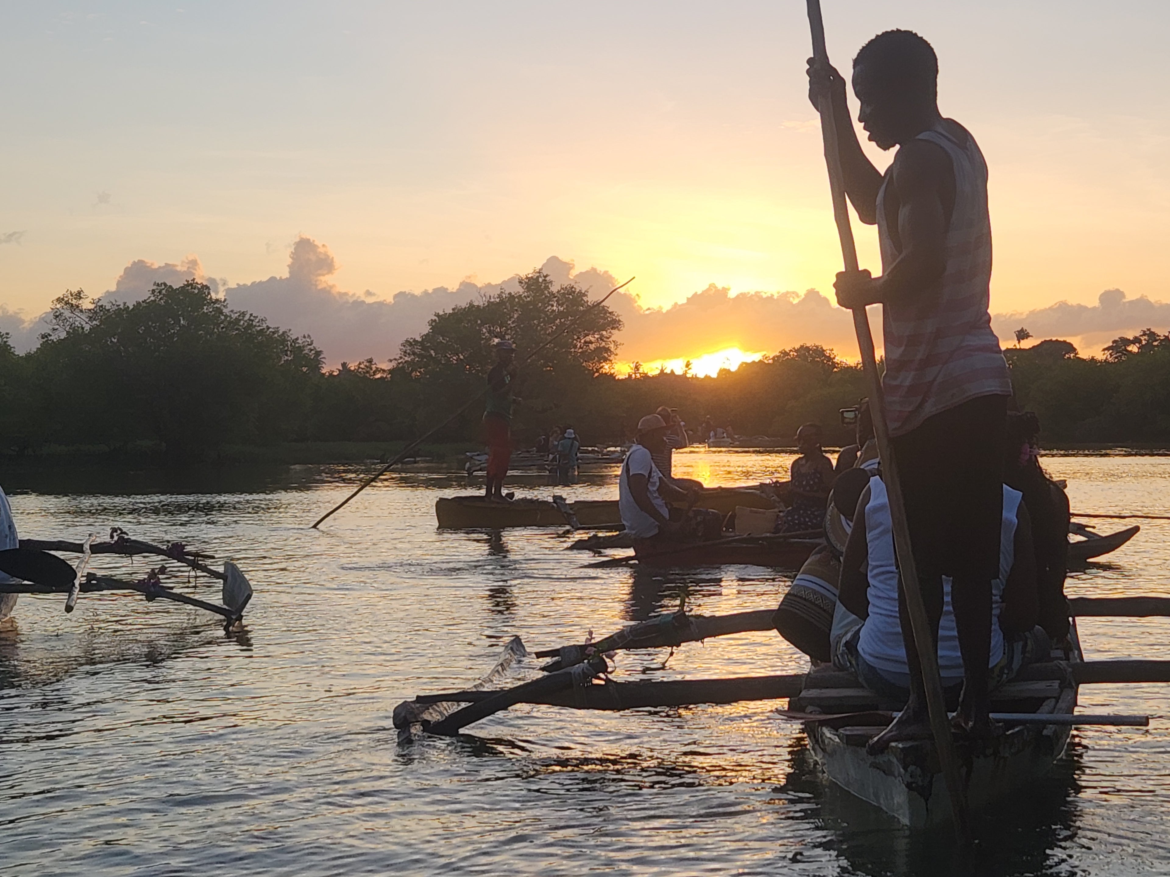 rowing canoies on a river Kongo at the golden hour
